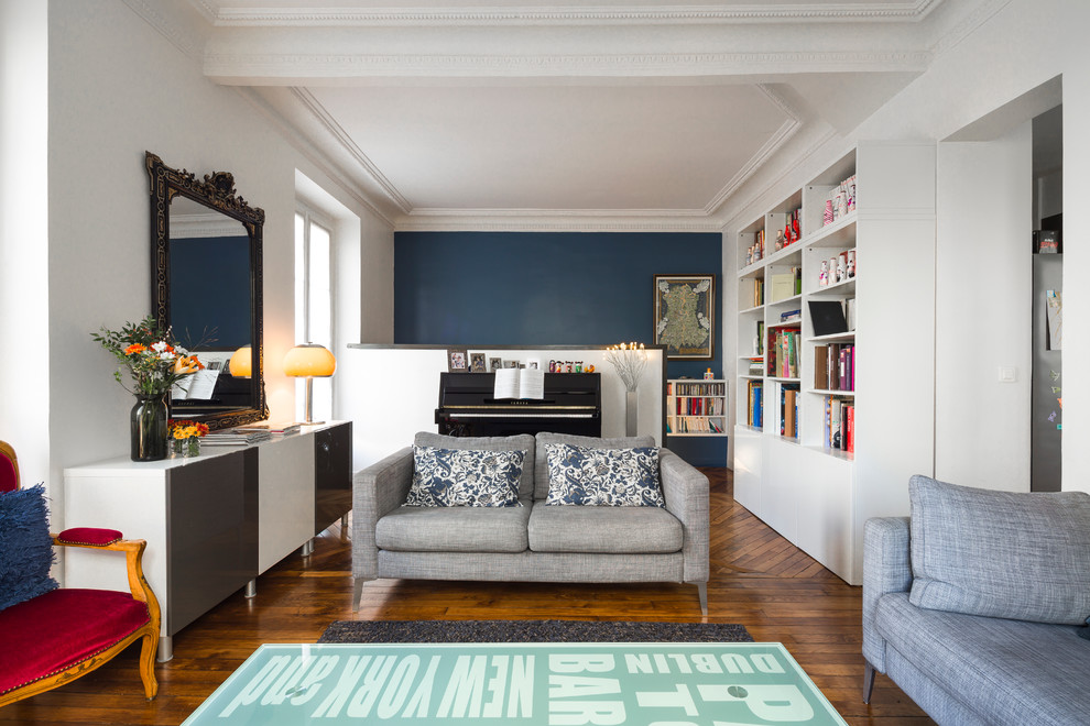 Eclectic living room in Paris with white walls and medium hardwood floors.