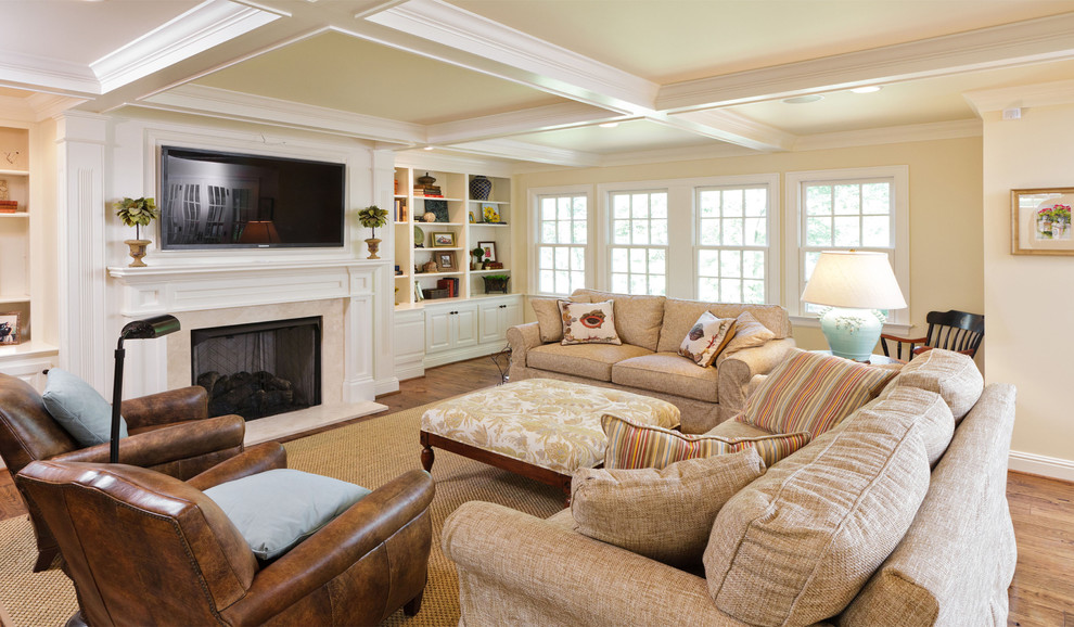 This is an example of a traditional family room in Louisville with beige walls, medium hardwood floors, a standard fireplace and a wall-mounted tv.
