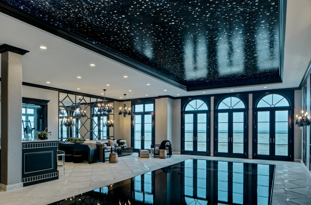 Photo of an expansive transitional indoor rectangular infinity pool in Chicago with a pool house and tile.