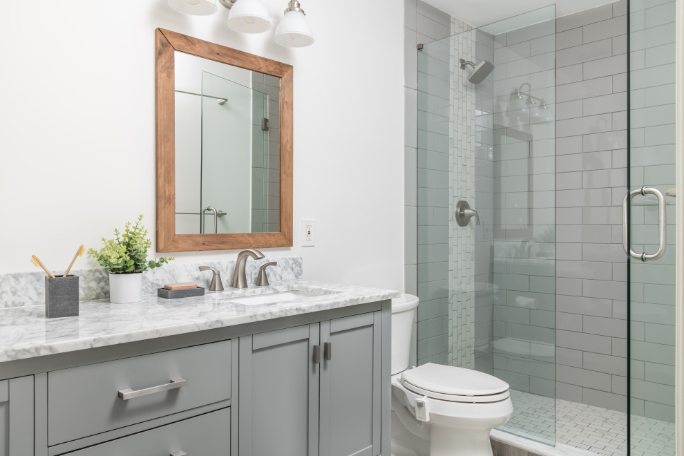 Inspiration for a small transitional master bathroom in Atlanta with recessed-panel cabinets, green cabinets, an alcove shower, a two-piece toilet, gray tile, ceramic tile, white walls, porcelain floors, an undermount sink, marble benchtops, grey floor, multi-coloured benchtops, a shower seat, a double vanity and a freestanding vanity.