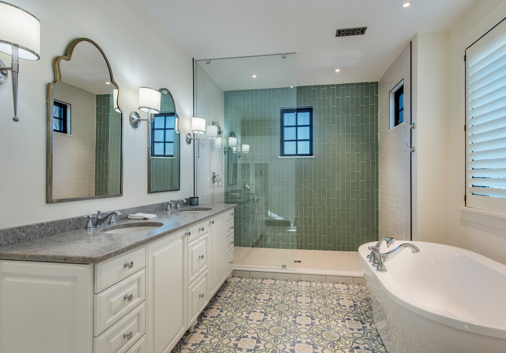 This is an example of a transitional master bathroom in Other with raised-panel cabinets, white cabinets, a freestanding tub, an open shower, green tile, white walls, an undermount sink, multi-coloured floor, an open shower, grey benchtops, a double vanity and a built-in vanity.