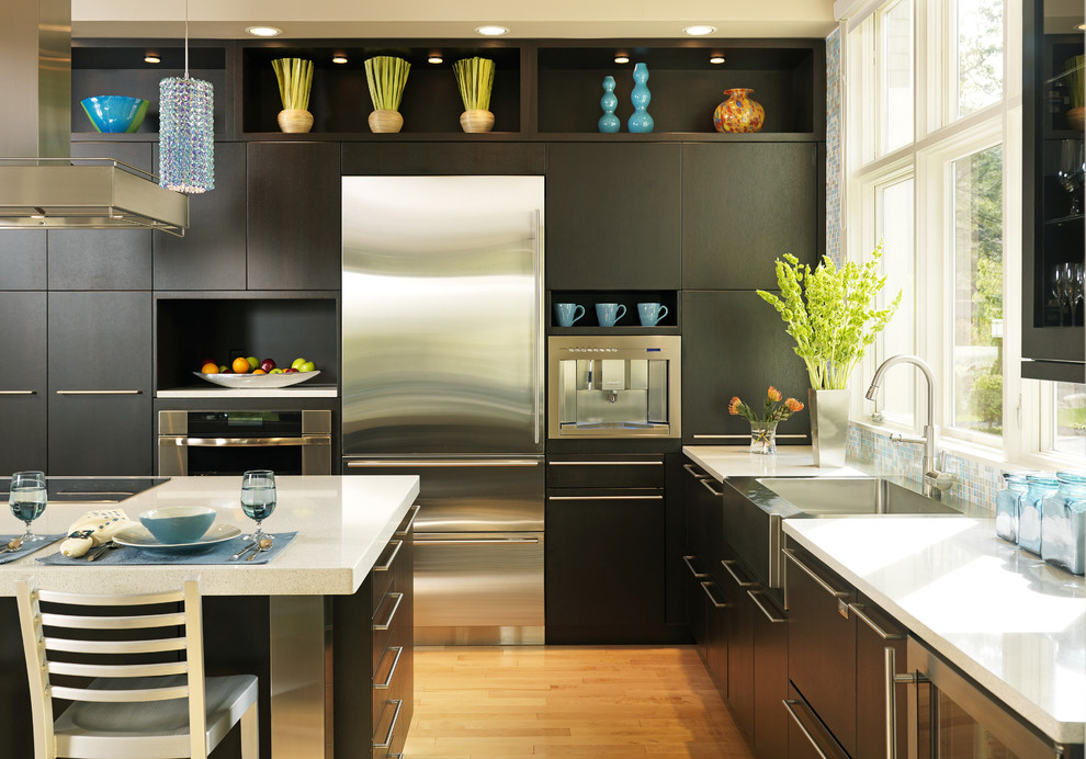 Design ideas for a contemporary kitchen in Boston with stainless steel appliances, a farmhouse sink, flat-panel cabinets, dark wood cabinets and quartz benchtops.