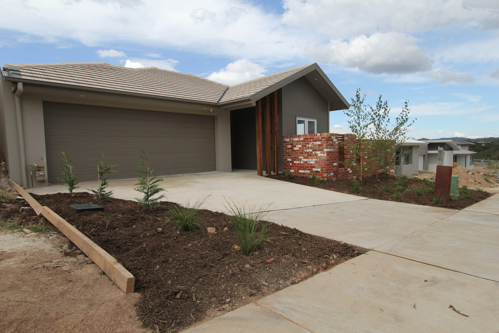This is an example of a small contemporary one-storey grey exterior in Canberra - Queanbeyan with concrete fiberboard siding.