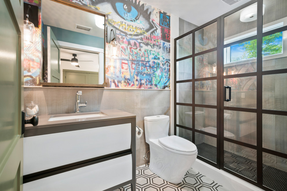 Design ideas for an industrial bathroom in Los Angeles with flat-panel cabinets, white cabinets, an alcove shower, a one-piece toilet, gray tile, multi-coloured walls, mosaic tile floors, an undermount sink, multi-coloured floor and grey benchtops.