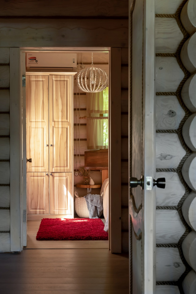 Modelo de vestíbulo posterior rústico pequeño con paredes beige, suelo laminado, puerta simple, puerta de madera en tonos medios, suelo beige, vigas vistas y madera