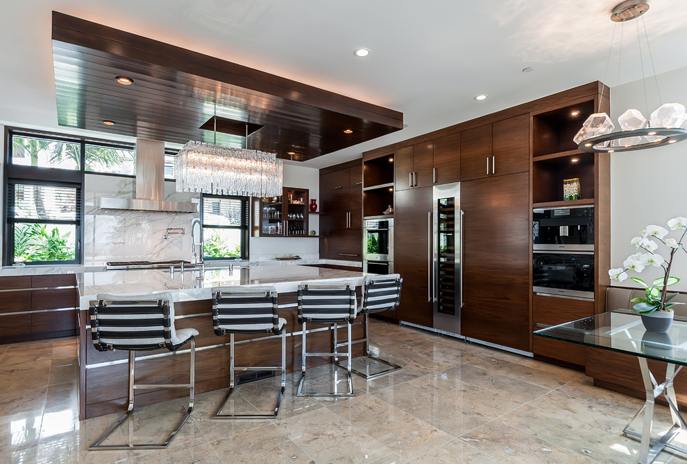 This is an example of a contemporary l-shaped eat-in kitchen in Los Angeles with flat-panel cabinets, medium wood cabinets, white splashback, stainless steel appliances, with island and beige floor.