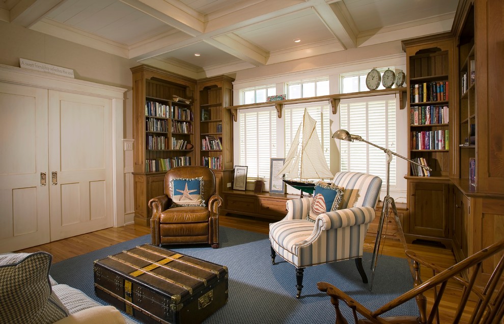 Inspiration for a beach style enclosed family room in Charleston with a library and beige walls.