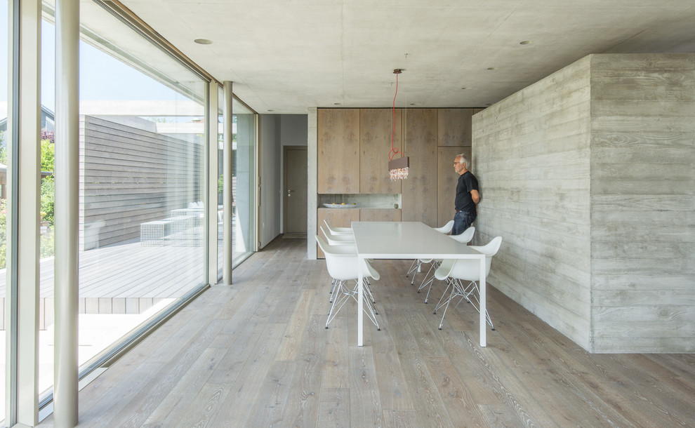 Large modern dining room in Stuttgart with grey walls and dark hardwood floors.