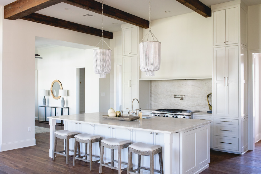 Inspiration for a beach style kitchen in New Orleans with an undermount sink, shaker cabinets, white cabinets, beige splashback, stone slab splashback, stainless steel appliances, dark hardwood floors, with island and brown floor.