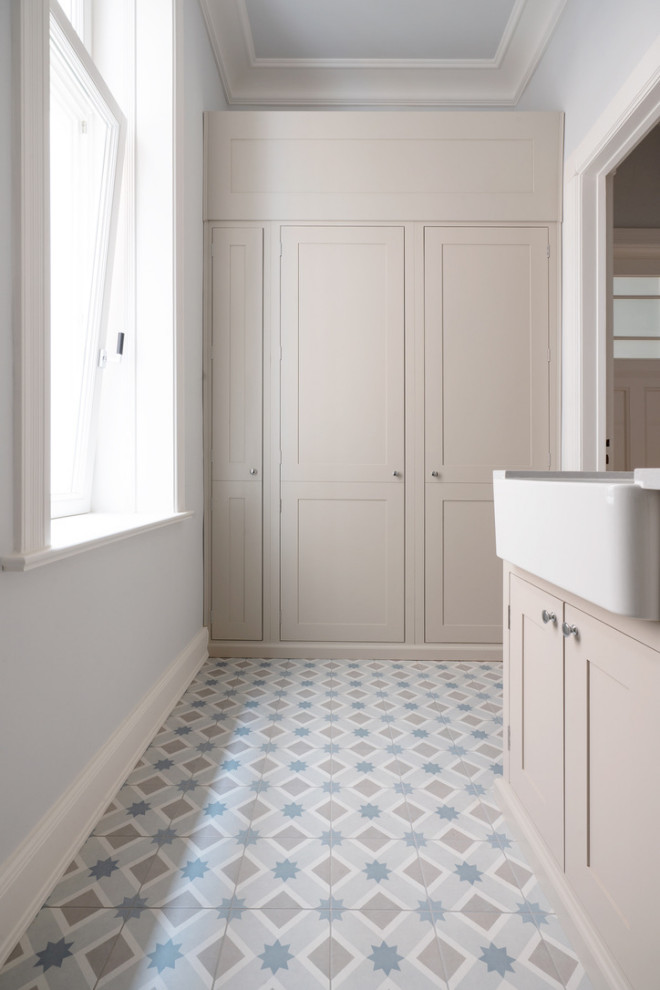 Exempel på en mellanstor lantlig grå linjär grått tvättstuga enbart för tvätt, med en rustik diskho, luckor med profilerade fronter, bänkskiva i kvartsit, blått stänkskydd, stänkskydd i keramik, grå väggar, klinkergolv i keramik, en tvättpelare och blått golv