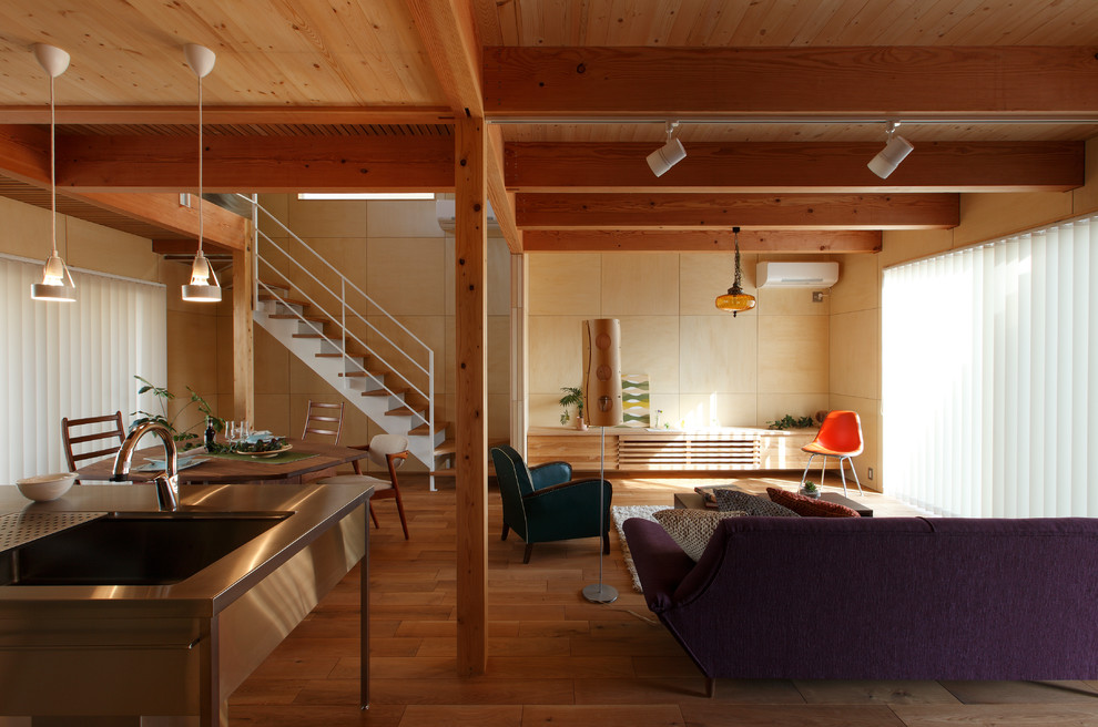 Photo of a midcentury open concept living room in Other with beige walls, medium hardwood floors and brown floor.