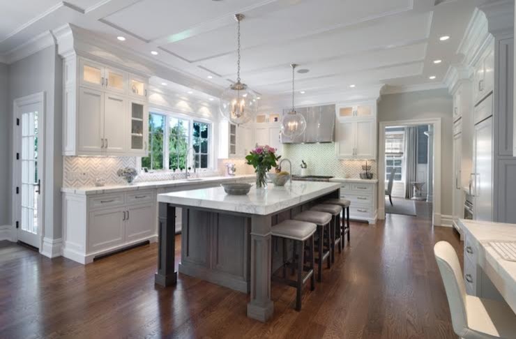 Inspiration for a large transitional u-shaped medium tone wood floor and brown floor enclosed kitchen remodel in Dallas with an undermount sink, recessed-panel cabinets, white cabinets, marble countertops, multicolored backsplash, ceramic backsplash, paneled appliances, an island and white countertops