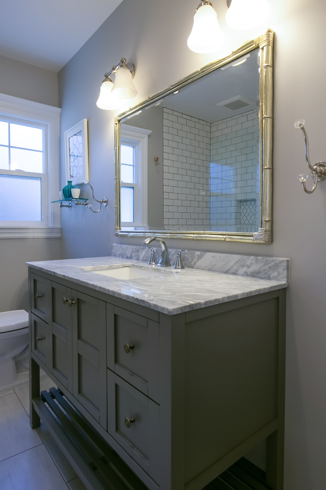Inspiration for a mid-sized transitional kids bathroom in San Francisco with furniture-like cabinets, grey cabinets, an alcove tub, a shower/bathtub combo, a two-piece toilet, white tile, subway tile, grey walls, porcelain floors, an undermount sink, engineered quartz benchtops, grey floor and an open shower.