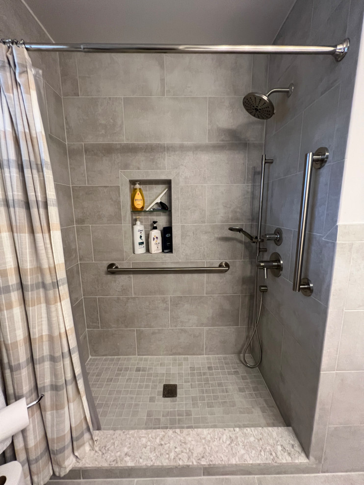 Photo of a small contemporary bathroom in Detroit with flat-panel cabinets, medium wood cabinets, an alcove shower, a two-piece toilet, gray tile, ceramic tile, white walls, porcelain floors, an undermount sink, engineered quartz benchtops, grey floor, a shower curtain, beige benchtops, a niche, a single vanity and a built-in vanity.