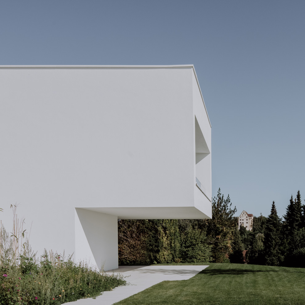 Inspiration pour une grande façade de maison minimaliste en stuc à trois étages et plus avec un toit plat et un toit en métal.