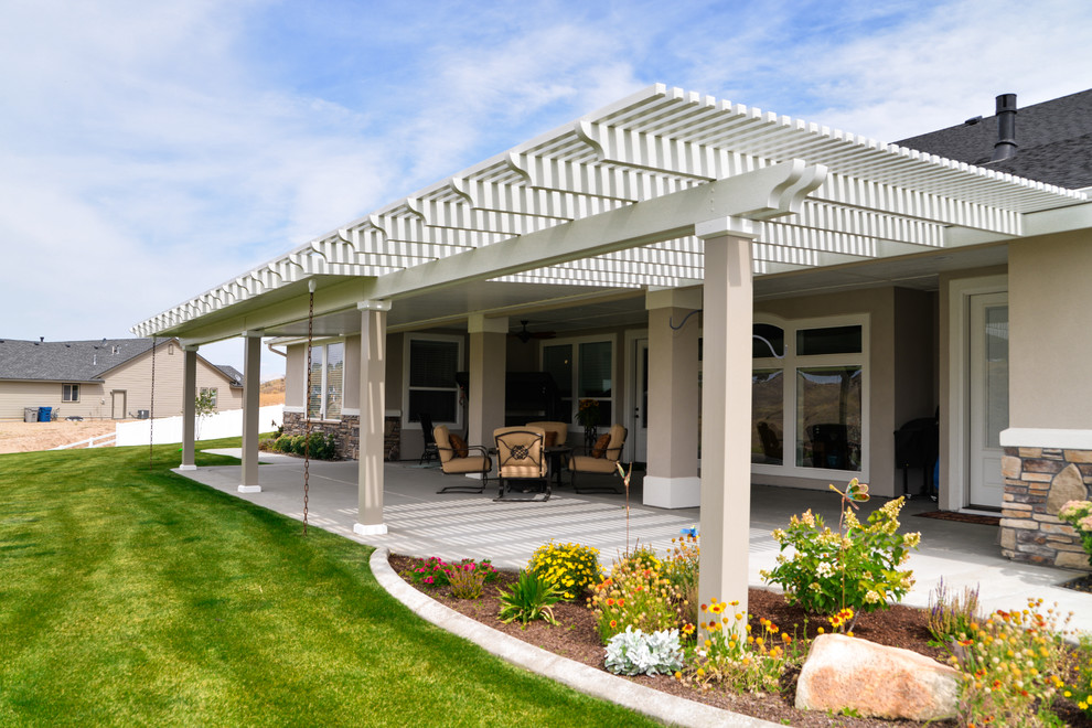 Patio - large transitional backyard patio idea in Boise with a roof extension