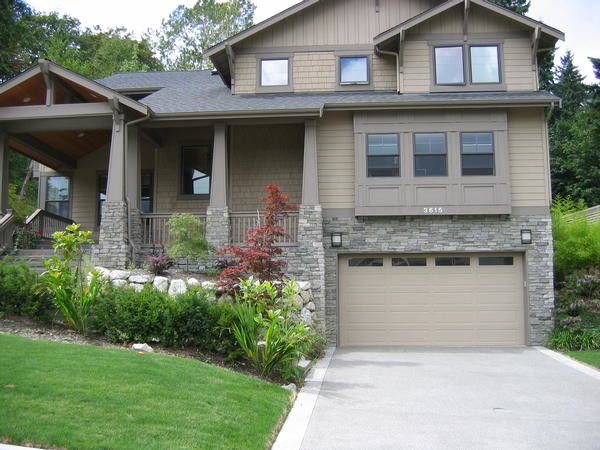 This is an example of a three-storey beige exterior in Seattle with stone veneer.