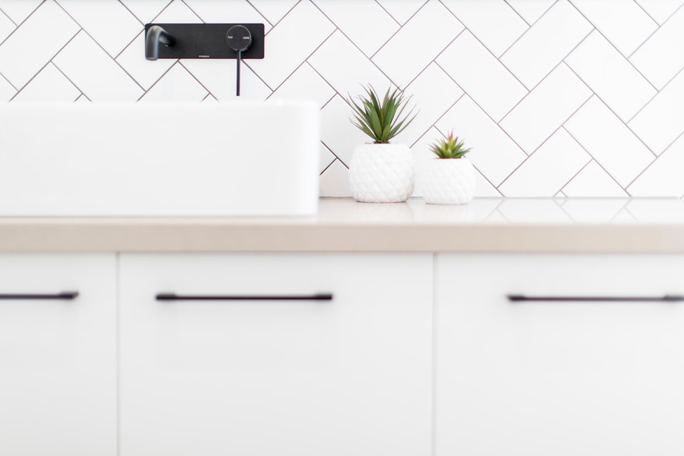 Contemporary bathroom in Geelong with flat-panel cabinets, white cabinets, a freestanding tub, an open shower, white tile, ceramic tile, white walls, ceramic floors, a vessel sink, engineered quartz benchtops, brown floor and beige benchtops.