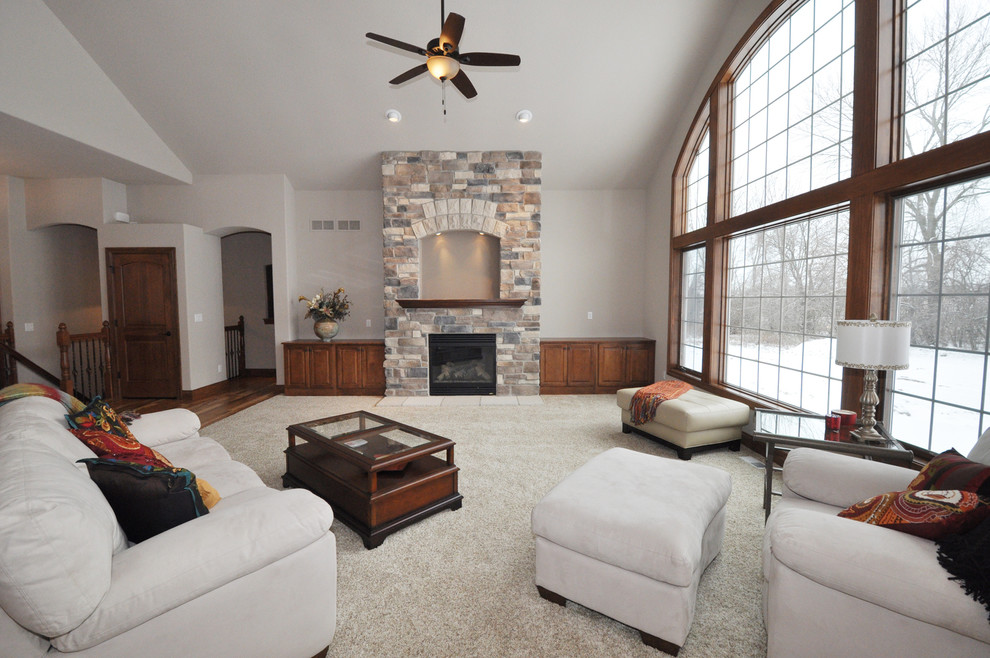 Photo of a large traditional open concept family room in Milwaukee with beige walls, carpet, a standard fireplace and a stone fireplace surround.