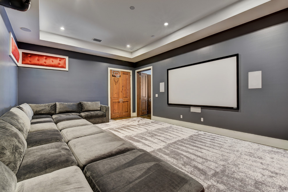 This is an example of a mid-sized transitional enclosed home theatre in Austin with grey walls, carpet, a projector screen and grey floor.