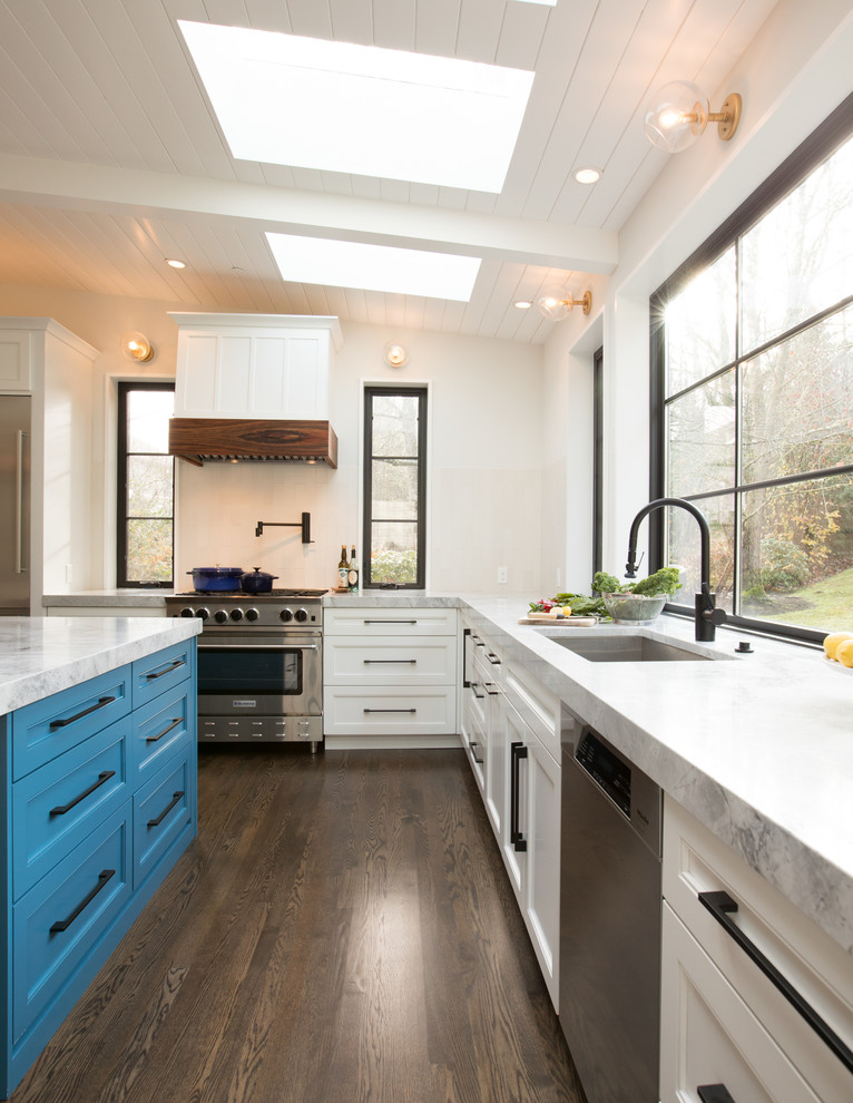 Photo of a large contemporary u-shaped eat-in kitchen in Seattle with an undermount sink, recessed-panel cabinets, white cabinets, quartzite benchtops, white splashback, ceramic splashback, stainless steel appliances, medium hardwood floors, with island, brown floor and grey benchtop.