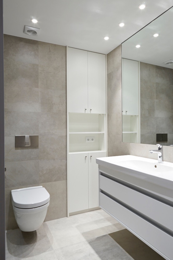 Design ideas for a small transitional powder room in Madrid with flat-panel cabinets, white cabinets, grey walls, an integrated sink and a wall-mount toilet.