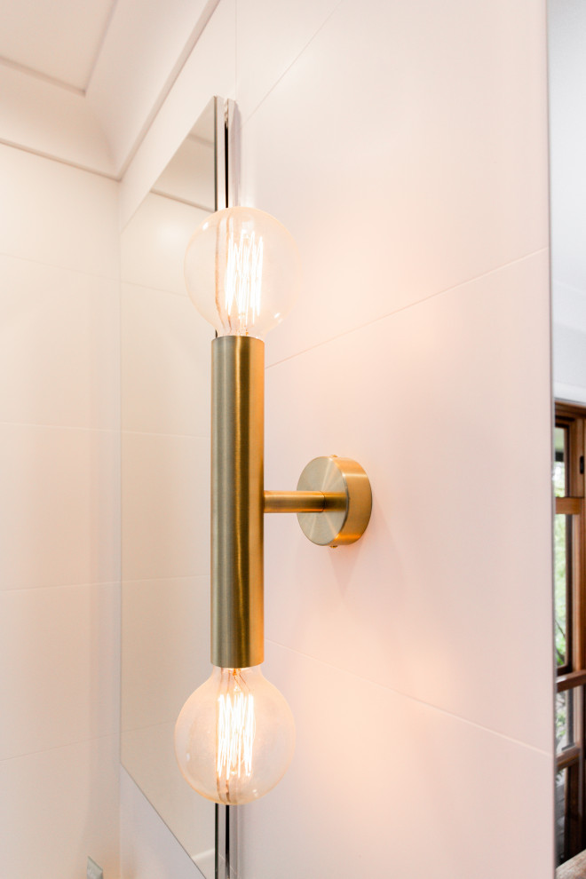 Design ideas for a mid-sized mediterranean 3/4 bathroom in Sydney with flat-panel cabinets, light wood cabinets, a freestanding tub, a corner shower, a two-piece toilet, an integrated sink, a hinged shower door, white benchtops, a niche, a double vanity and a floating vanity.