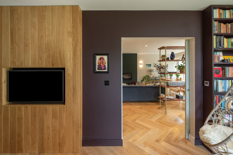 Idee per un home theatre design di medie dimensioni con pareti viola e pavimento in legno massello medio