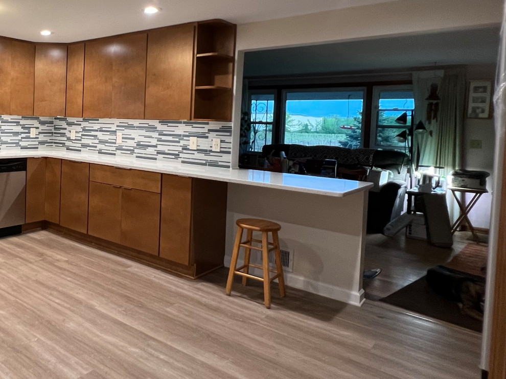 This is an example of a large classic u-shaped kitchen pantry in Cleveland with flat-panel cabinets, medium wood cabinets and engineered stone countertops.