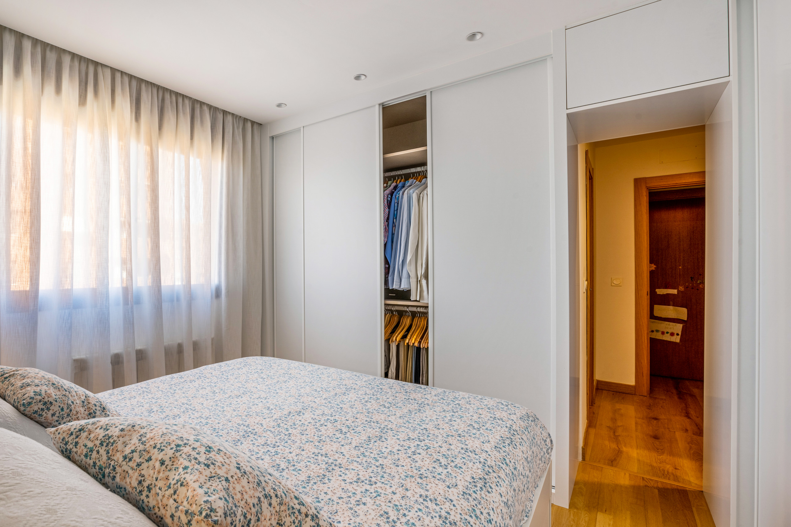 Dormitorio y vestidor en L con paso bajo altillo.