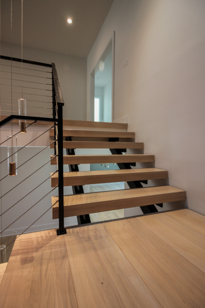 Diseño de escalera suspendida bohemia grande con escalones de madera, barandilla de metal y ladrillo
