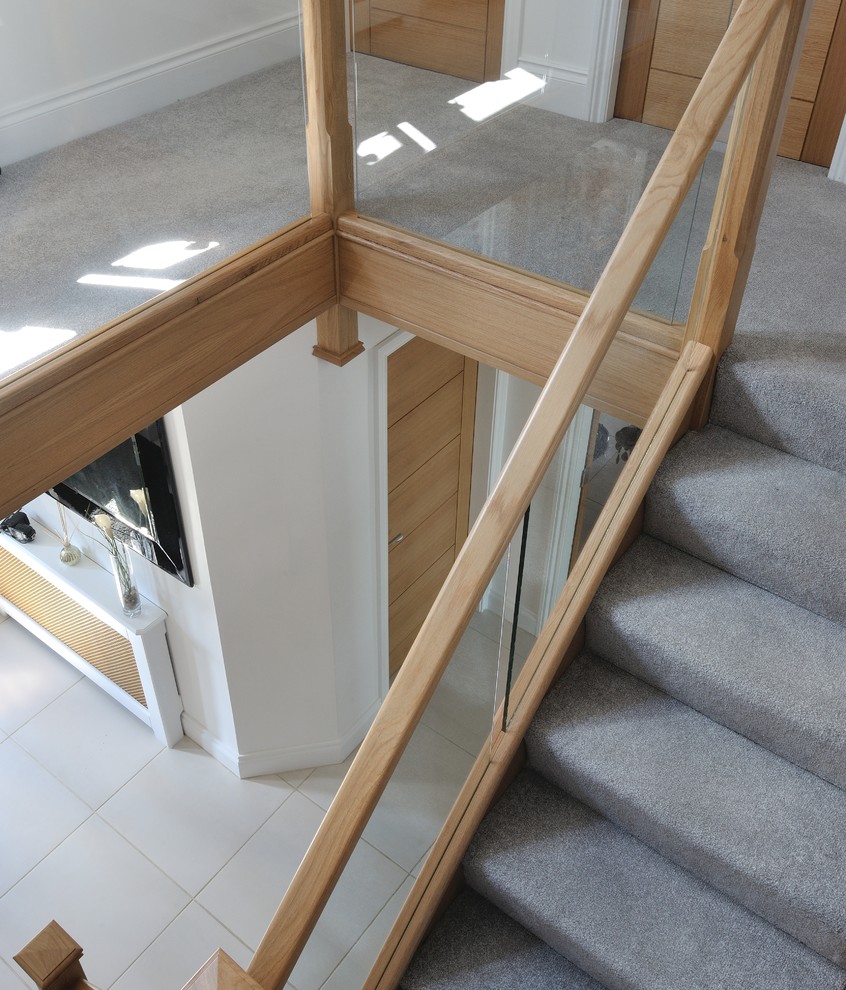 Photo of a mid-sized contemporary carpeted l-shaped staircase in Other with wood risers.