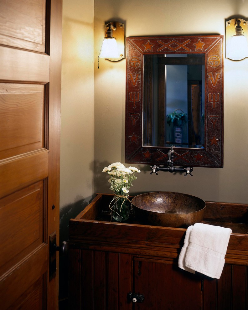 This is an example of a country powder room in Omaha with a vessel sink.