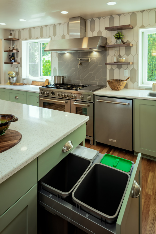 Example of a large transitional l-shaped medium tone wood floor eat-in kitchen design with an undermount sink, shaker cabinets, green cabinets, quartz countertops, gray backsplash, ceramic backsplash, stainless steel appliances, an island and white countertops