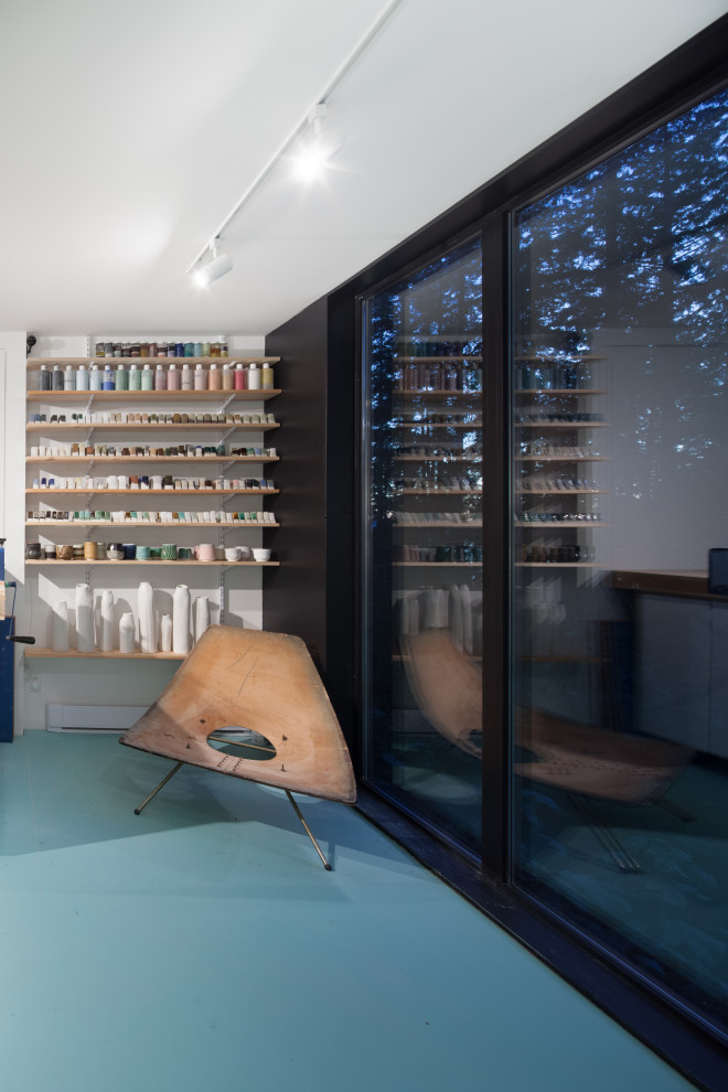 Idée de décoration pour un bureau design de type studio avec un mur blanc, sol en béton ciré et un sol bleu.