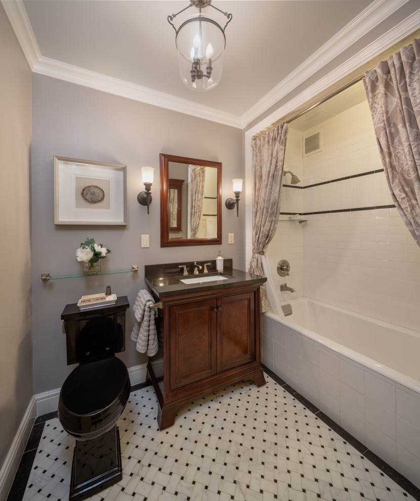 This is an example of a traditional 3/4 bathroom in New York with beaded inset cabinets, dark wood cabinets, an alcove tub, a shower/bathtub combo, a two-piece toilet, white tile, grey walls, mosaic tile floors, an undermount sink, white floor, a shower curtain, black benchtops, a single vanity and a freestanding vanity.