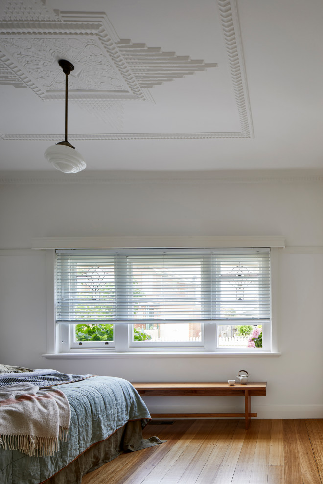 This is an example of a small contemporary master bedroom in Melbourne with white walls, medium hardwood floors, brown floor and coffered.
