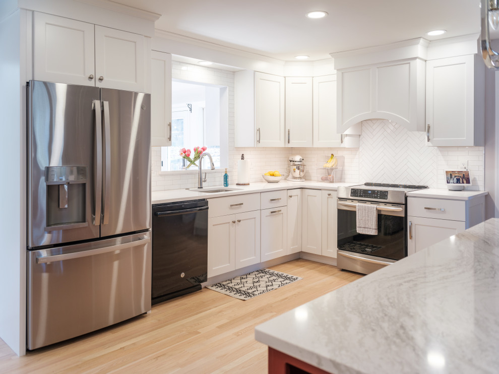 Kitchen - transitional u-shaped light wood floor and beige floor kitchen idea with an undermount sink, shaker cabinets, white cabinets, white backsplash, subway tile backsplash, stainless steel appliances, no island and white countertops
