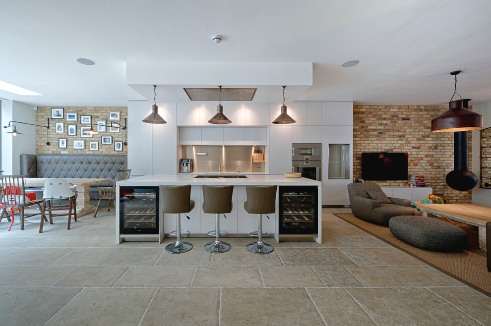 Contemporary open plan kitchen in Surrey with flat-panel cabinets, white cabinets, metallic splashback, stainless steel appliances and with island.