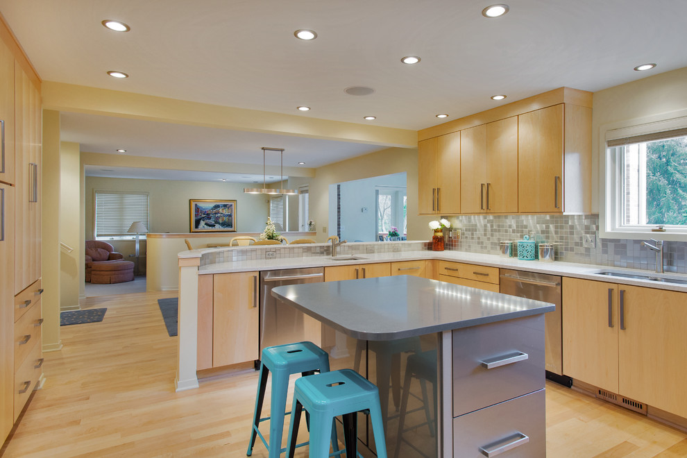 Example of a large transitional u-shaped light wood floor eat-in kitchen design with an undermount sink, flat-panel cabinets, light wood cabinets, quartzite countertops, metallic backsplash, metal backsplash, stainless steel appliances and an island