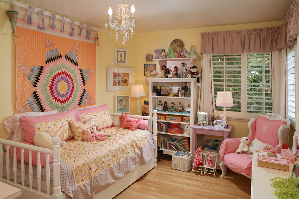 Design ideas for a contemporary kids' bedroom for kids 4-10 years old and girls in Los Angeles with yellow walls and light hardwood floors.