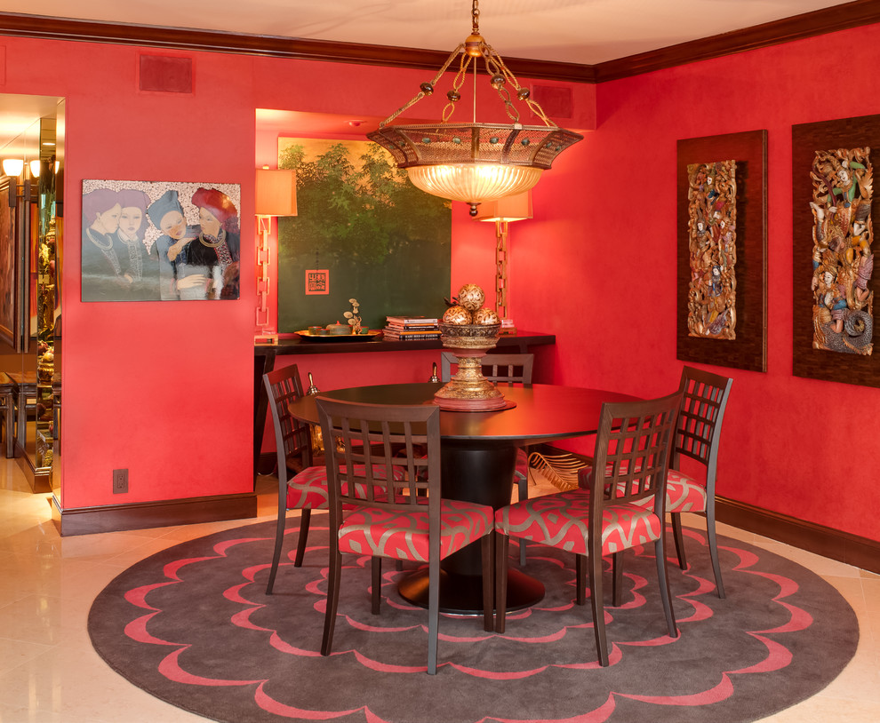 This is an example of an asian dining room in Miami with red walls.