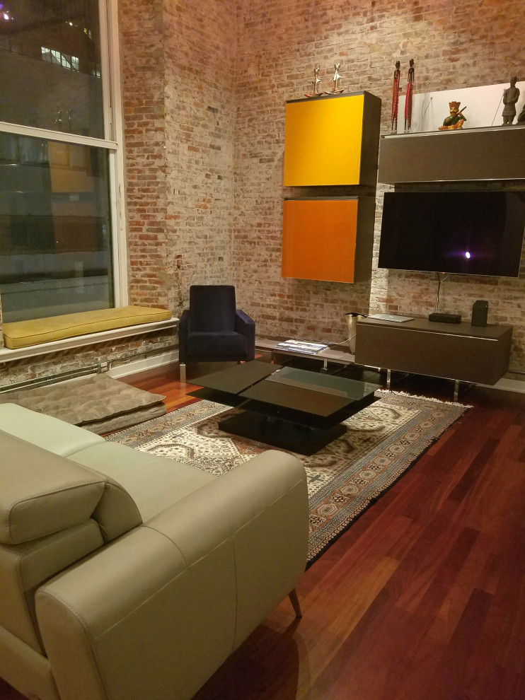 Photo of a mid-sized industrial loft-style living room in Philadelphia with white walls, medium hardwood floors, a wall-mounted tv and red floor.