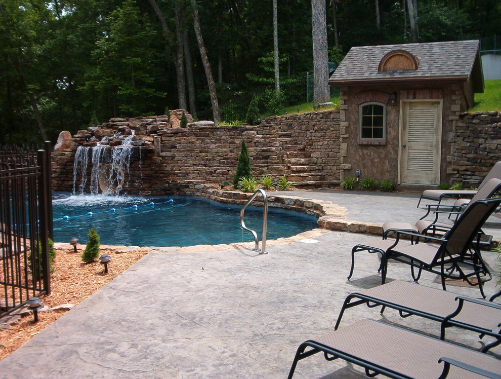 Inspiration for a large country backyard custom-shaped natural pool in Other with a pool house and stamped concrete.