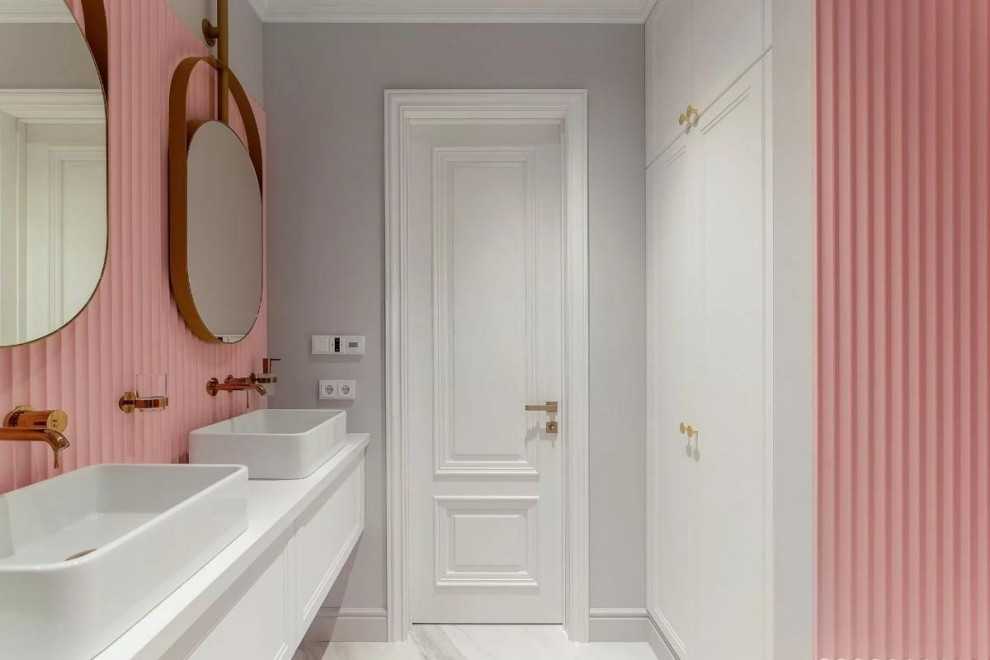На фото: большая детская, серо-белая ванная комната в современном стиле с фасадами с выступающей филенкой, белыми фасадами, ванной в нише, инсталляцией, розовой плиткой, серыми стенами, полом из керамогранита, накладной раковиной, столешницей из искусственного камня, серым полом, душем с распашными дверями, белой столешницей, зеркалом с подсветкой, тумбой под две раковины, подвесной тумбой, многоуровневым потолком и панелями на части стены с