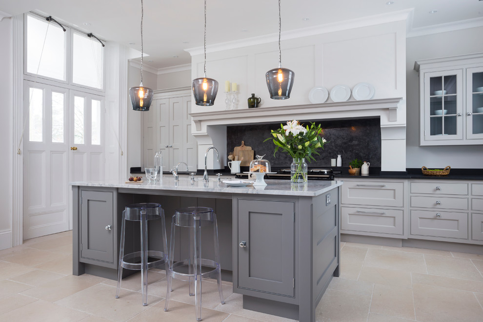 Large transitional open plan kitchen in Hampshire with grey cabinets, black splashback, with island, a double-bowl sink, beaded inset cabinets, granite benchtops and limestone floors.