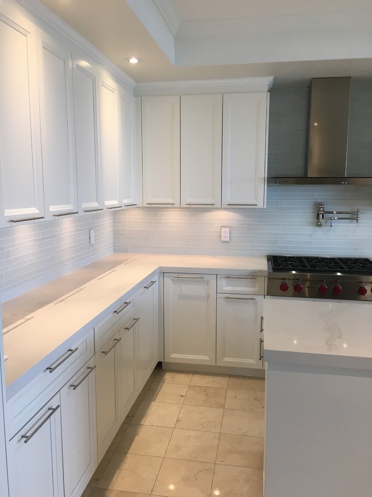 Mid-sized transitional u-shaped porcelain tile open concept kitchen photo in Toronto with a double-bowl sink, recessed-panel cabinets, white cabinets, marble countertops, white backsplash, glass tile backsplash, stainless steel appliances and an island