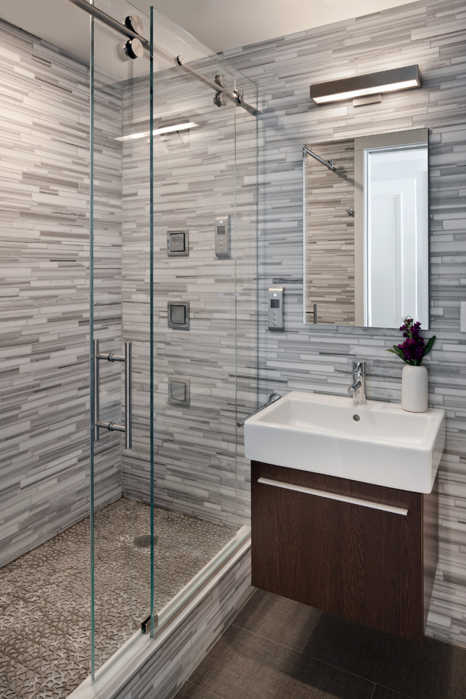 Photo of a contemporary master bathroom in New York with a wall-mount sink, flat-panel cabinets, dark wood cabinets, an alcove shower, gray tile, matchstick tile, multi-coloured walls and ceramic floors.