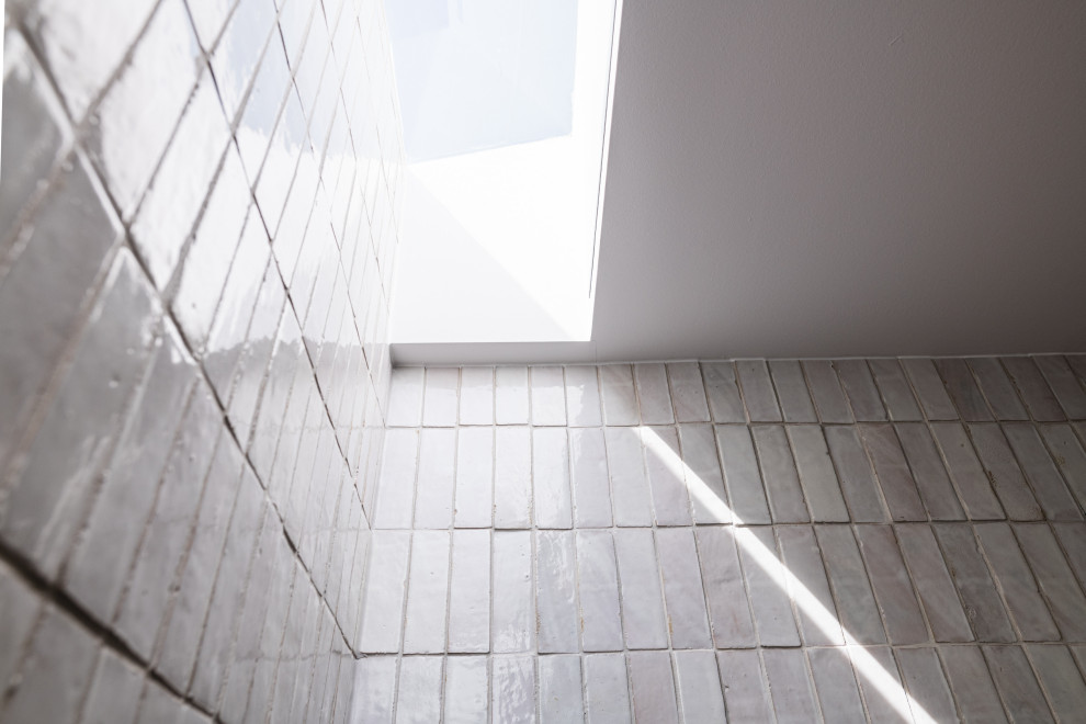 Пример оригинального дизайна: ванная комната среднего размера в морском стиле с душем в нише, белой плиткой, удлиненной плиткой, белыми стенами, полом из терраццо, разноцветным полом, открытым душем и сводчатым потолком