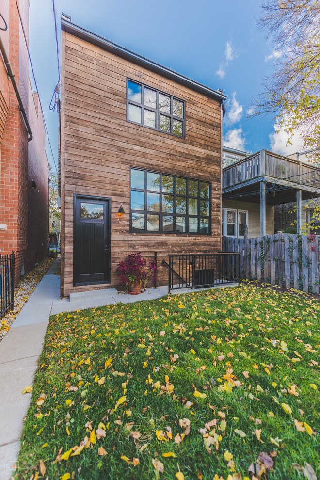 Traditional three-storey exterior in Chicago with wood siding and a flat roof.